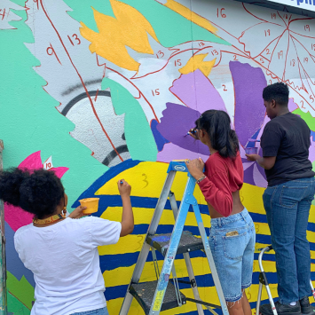 A group of youth from VPI's E2E program support the painting of a Community Mural in the Bywater area of New Orleans.