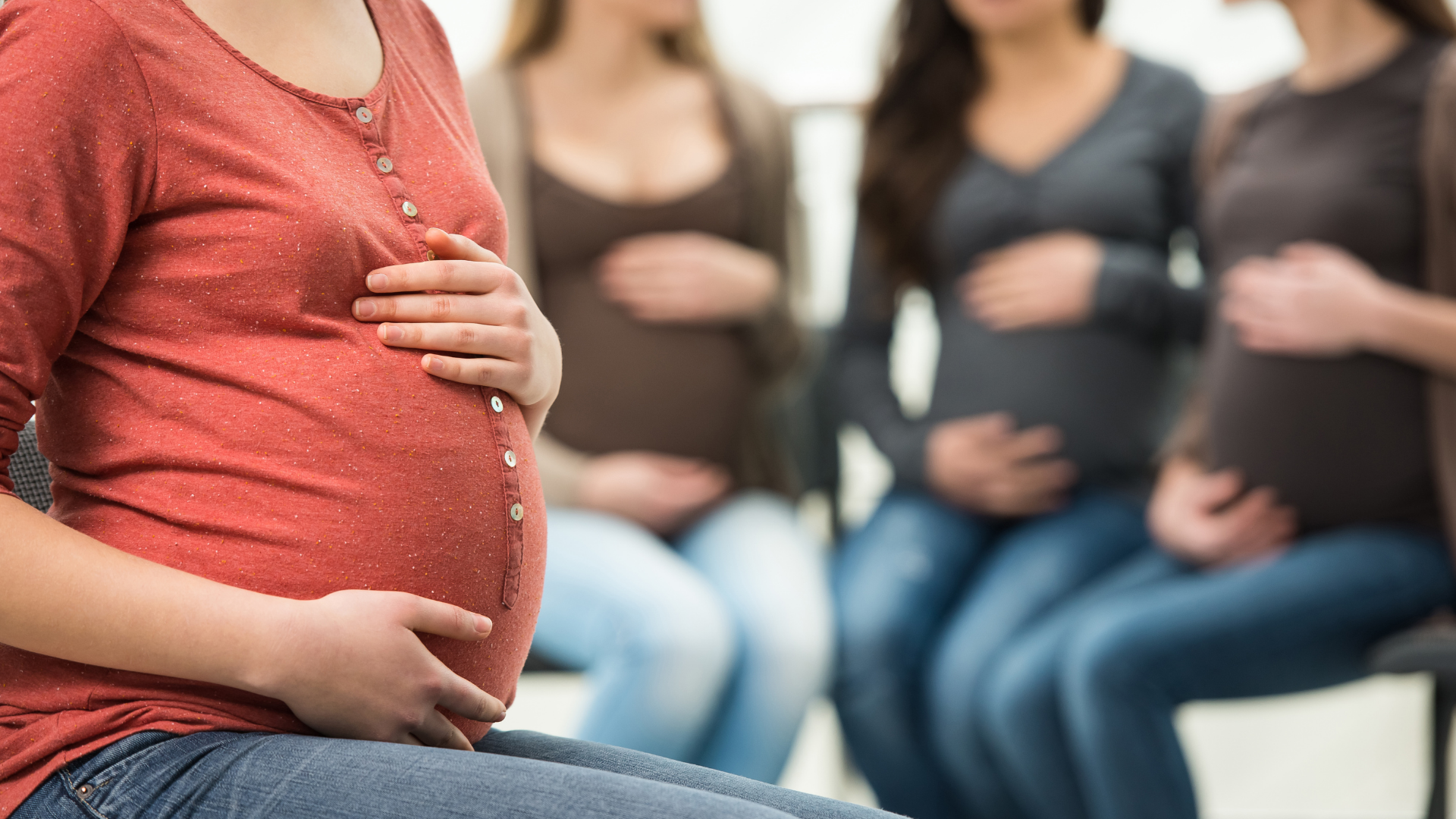Multiple seated pregnant women