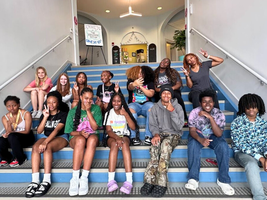 E2E Participants sit on steps in the Broadmoor Arts & Wellness Center.